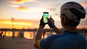 Man in bicycle helmet plays Pokemon Go on cellphone