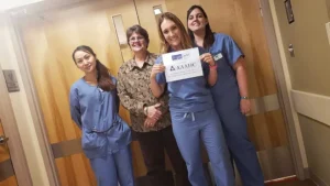 Group of female staff members hold AAAHC accreditation document