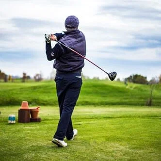 Man golfs on grassy field during the day