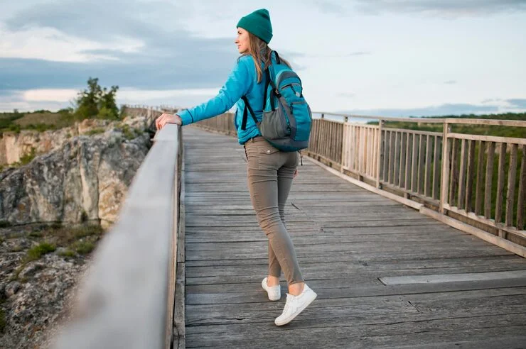 Young female traveler wearing backpack while walking outdoors