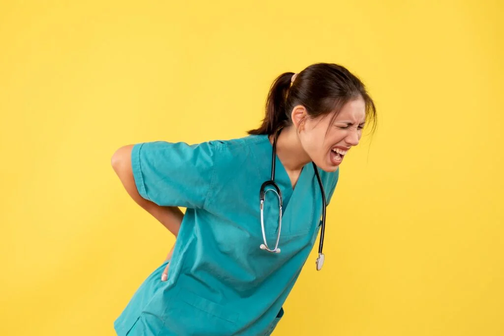 Healthcare provider in scrubs experiences back pain