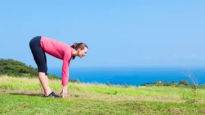 Woman exercising outside bends over to stretch
