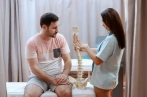 Female provider shows male patient 3D spine model