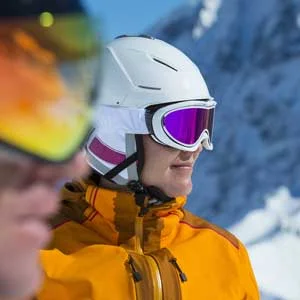 Person wearing winter ski attire and sunglasses outdoors looks ahead