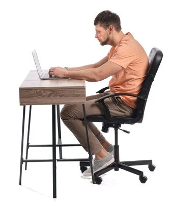 Man sits at work desk hunched over with bad posture