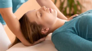Chiropractor adjusts neck of young female patient