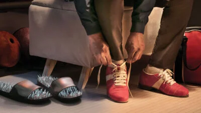 Person bends over tying red shoes