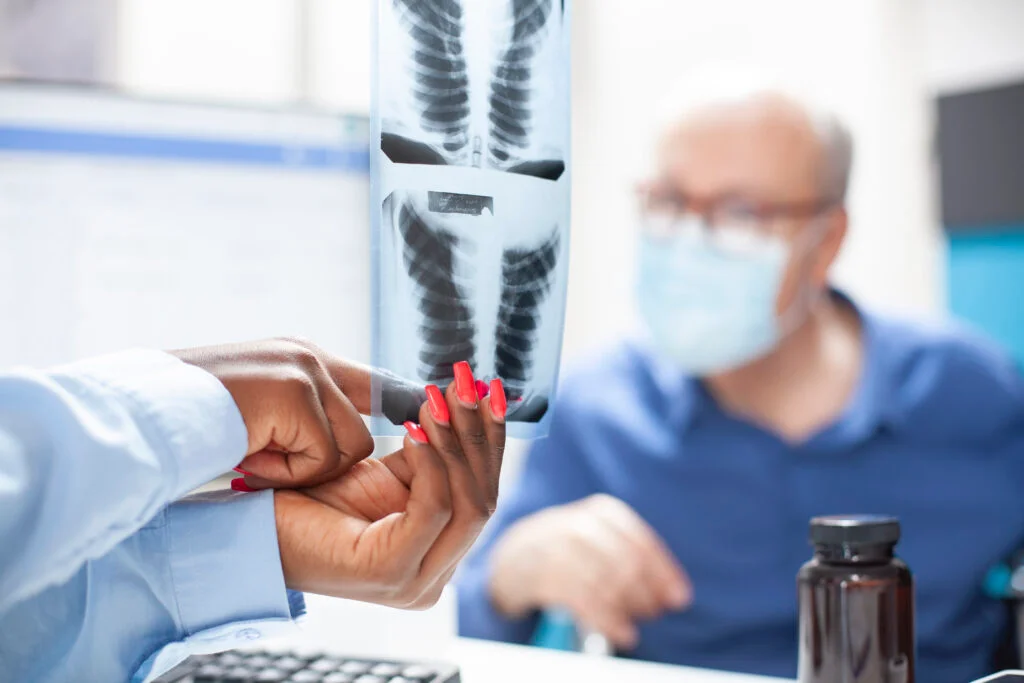 Provider points to X-rays in front of male patient