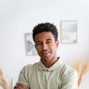 Man in polo shirt casually smiles at home
